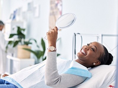 Woman smiling while looking at reflection in mirror