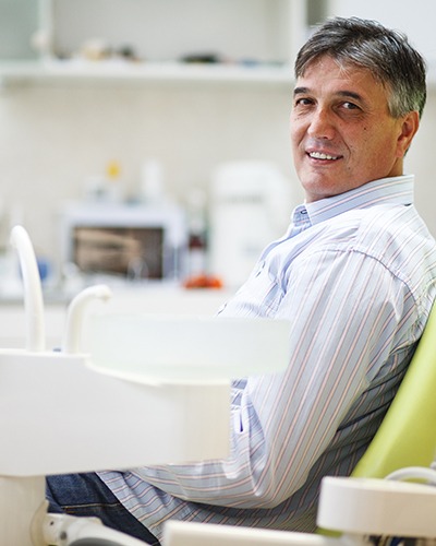 Man smiling while sitting in treatment chair