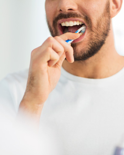 Patient in Mississauga brushing their teeth after teeth whitening