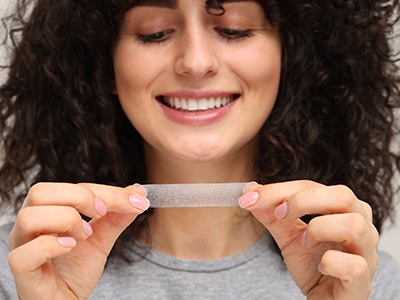 Woman holding a whitening strip