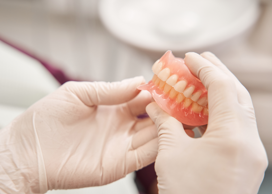 Hands holding dentures