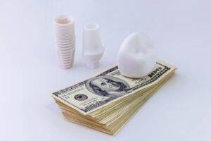 Dental implants on a stack of cash